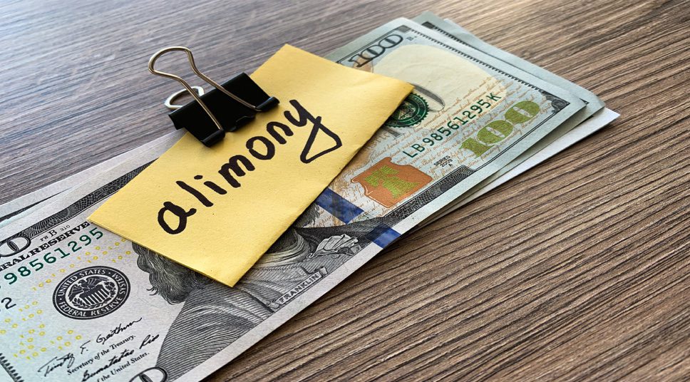 A stack of money with paper marked alimony, when need to modify your spousal support payments speak to a Sterling Heights Alimony Attorney.