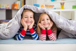 Two siblings lying under blanket for the best representation turn to Birmingham Family Law Lawyers.