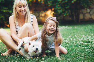 Child with mother playing with dog, turn to family law attorney Birmingham.